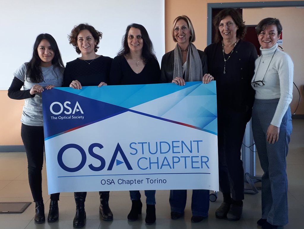 Members of the OSA Torino Student Chapter holding their chapter flag.
